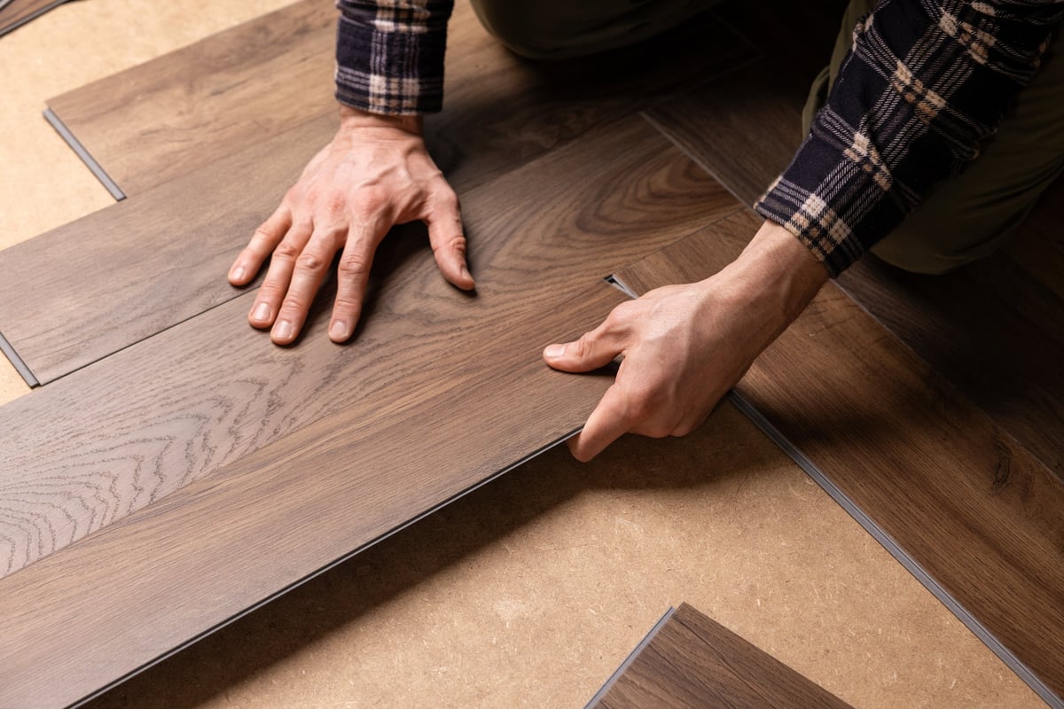 Professional contractor installing vinyl plank flooring — commercial flooring installation